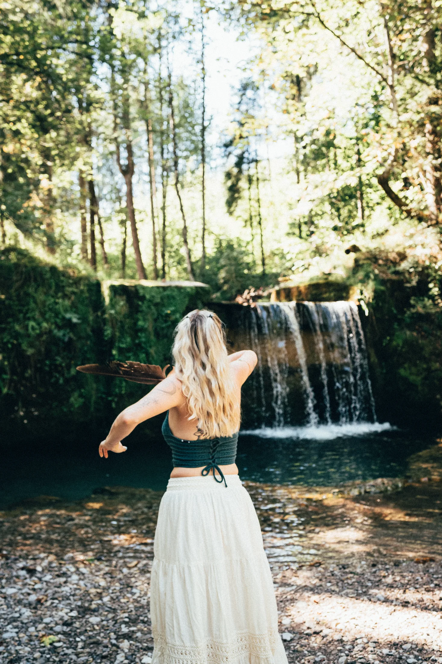 Antonia steht mit dem Rücken zum Wasserfall